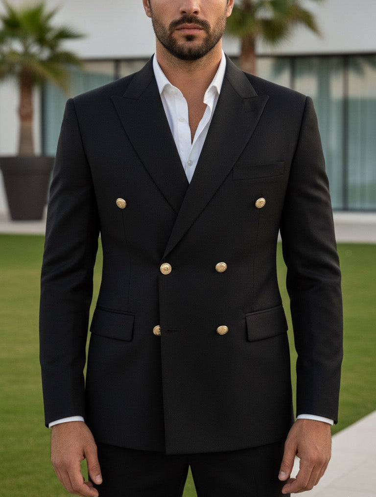 Man wearing a black double-breasted suit with gold buttons outdoors.